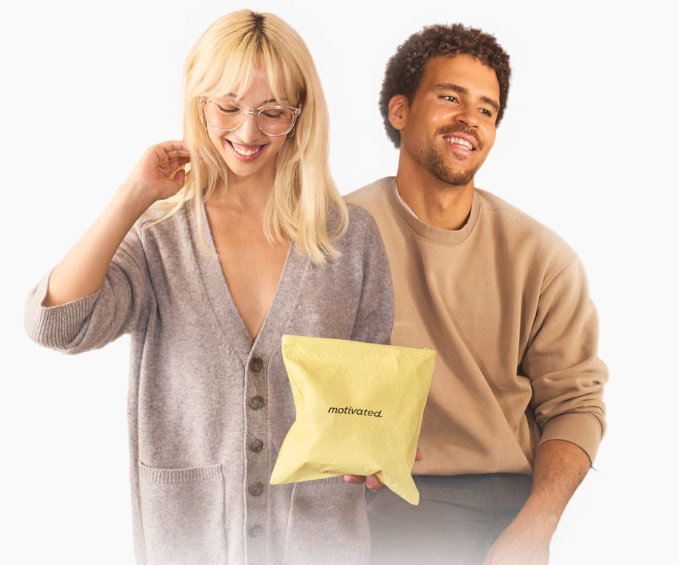 Woman and man smiling, holding a Motivated pouch